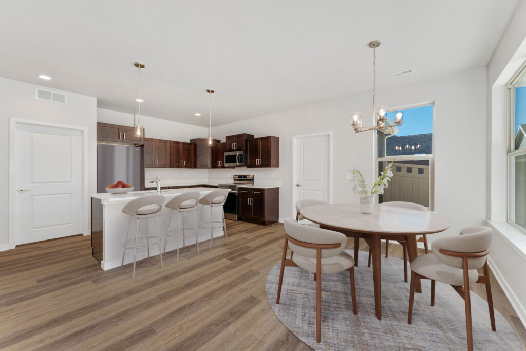 Modern open kitchen and dining area with wooden floors.